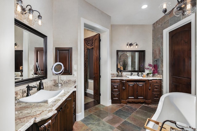 2219 Clubs Dr, Boerne, TX 78006 - full bathroom featuring stone tile flooring, a freestanding bath, two vanities, and baseboards