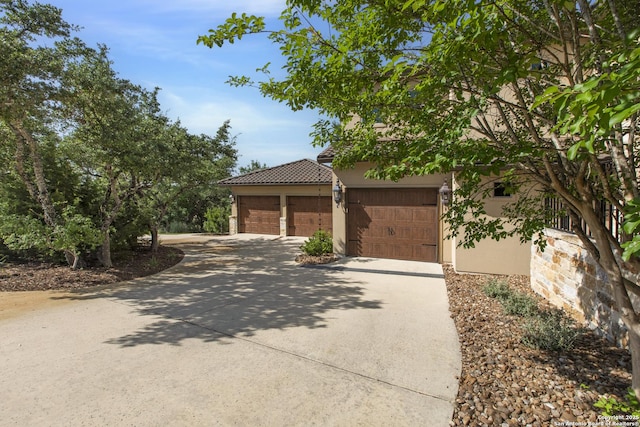 2219 Clubs Dr, Boerne, TX 78006 - view of front of home featuring concrete driveway, stucco siding, an attached garage, and a tile roof