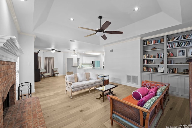 9403 Gardenia Bnd, San Antonio, TX 78266 - living room with a raised ceiling, a ceiling fan, a fireplace, light wood-style floors, and recessed lighting