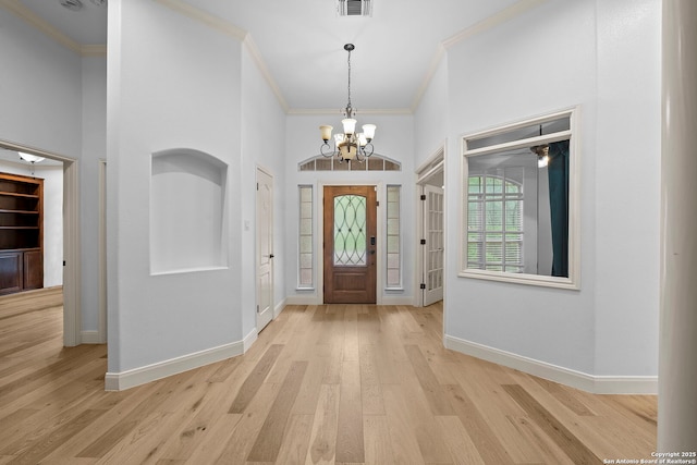 9403 Gardenia Bnd, San Antonio, TX 78266 - foyer with crown molding, a chandelier, light wood finished floors, and baseboards