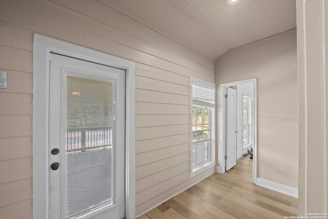 9403 Gardenia Bnd, San Antonio, TX 78266 - entryway with light wood-style flooring, wood walls, vaulted ceiling, and baseboards