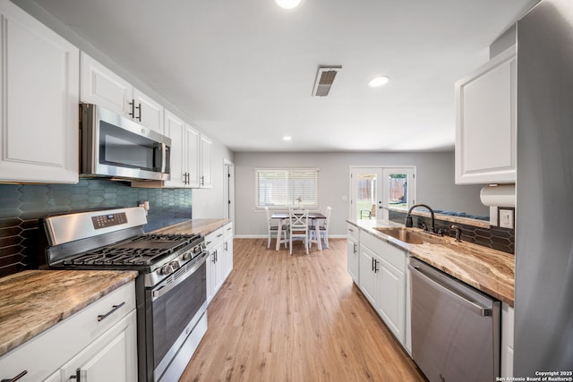 5902 Brambletree, San Antonio, TX 78247 - kitchen with stainless steel appliances, a sink, white cabinets, decorative backsplash, and recessed lighting
