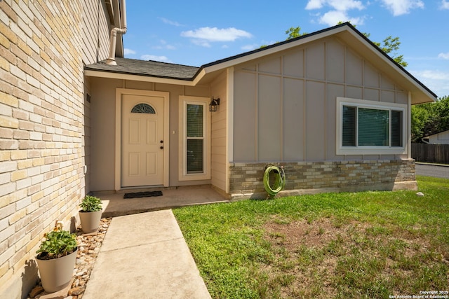 5902 Brambletree, San Antonio, TX 78247 - view of exterior entry with board and batten siding, brick siding, roof with shingles, and a yard