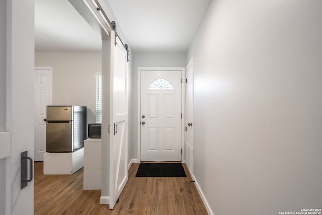 5902 Brambletree, San Antonio, TX 78247 - doorway with wood finished floors, a barn door, and baseboards