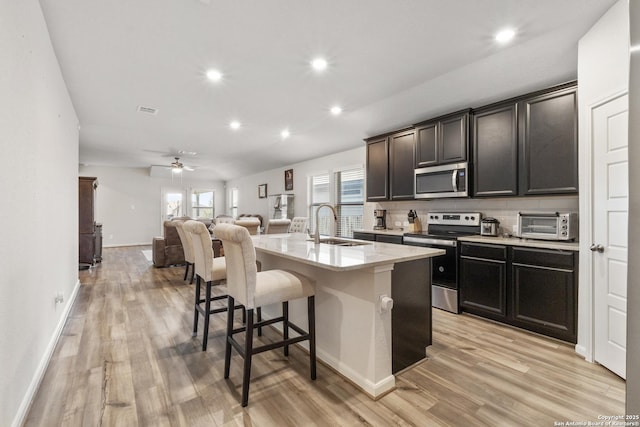 4540 Appaloosa, San Antonio, TX 78245 - kitchen featuring appliances with stainless steel finishes, open floor plan, a kitchen breakfast bar, recessed lighting, and light wood-type flooring