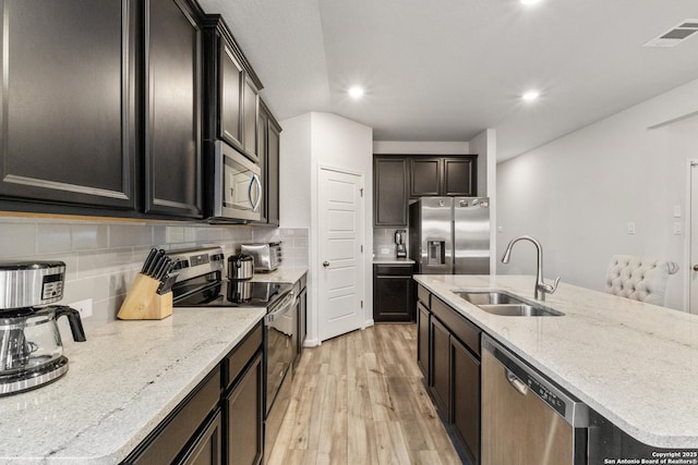 4540 Appaloosa, San Antonio, TX 78245 - kitchen with stainless steel appliances, a sink, light wood-style flooring, backsplash, and recessed lighting