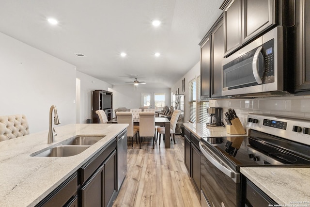 4540 Appaloosa, San Antonio, TX 78245 - kitchen featuring appliances with stainless steel finishes, a sink, open floor plan, recessed lighting, and light wood finished floors