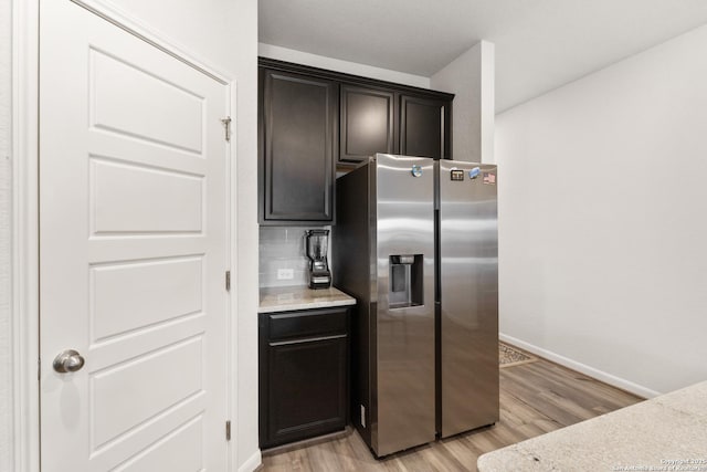 4540 Appaloosa, San Antonio, TX 78245 - kitchen with stainless steel refrigerator with ice dispenser, light wood-style flooring, baseboards, and tasteful backsplash