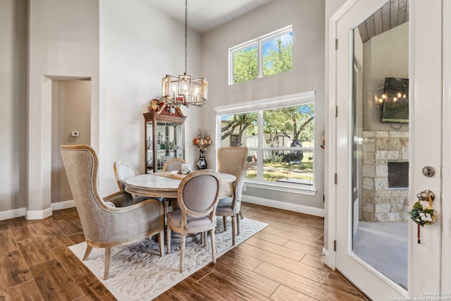 2319 Cascada, Spring Branch, TX 78070 - dining area featuring baseboards, a high ceiling, a chandelier, dark wood-style flooring, and plenty of natural light
