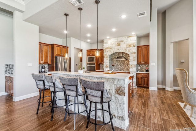 2319 Cascada, Spring Branch, TX 78070 - kitchen featuring appliances with stainless steel finishes, brown cabinets, tasteful backsplash, light countertops, and dark wood-style floors