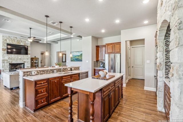 2319 Cascada, Spring Branch, TX 78070 - kitchen with a stone fireplace, stainless steel appliances, a large island with sink, a sink, and open floor plan