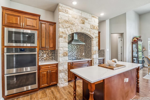 2319 Cascada, Spring Branch, TX 78070 - kitchen featuring wall chimney exhaust hood, double oven, built in microwave, a kitchen bar, and black electric cooktop
