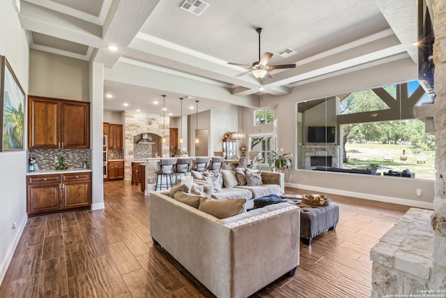 2319 Cascada, Spring Branch, TX 78070 - living area featuring a stone fireplace, dark wood-style flooring, ceiling fan, coffered ceiling, and beam ceiling
