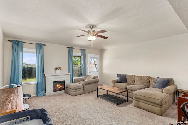 160 Jolie, Boerne, TX 78015 - living room with carpet floors, ceiling fan, a lit fireplace, and a textured ceiling