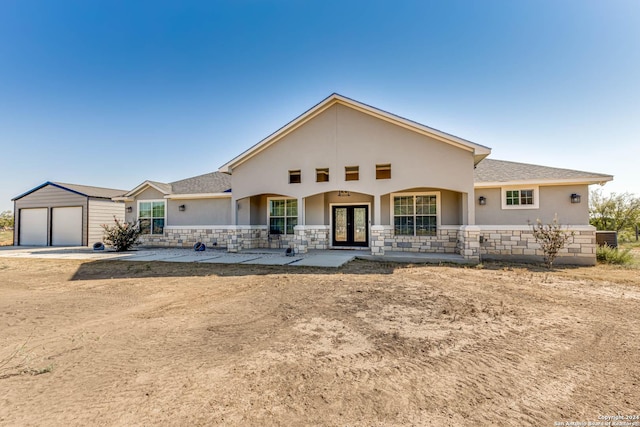 19146 Mcconnell Rd, Atascosa, TX 78002 - view of front of property with french doors, stucco siding, a garage, an outdoor structure, and stone siding
