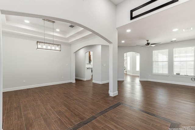 19146 Mcconnell Rd, Atascosa, TX 78002 - unfurnished living room with a raised ceiling, dark wood-style flooring, a ceiling fan, arched walkways, and recessed lighting