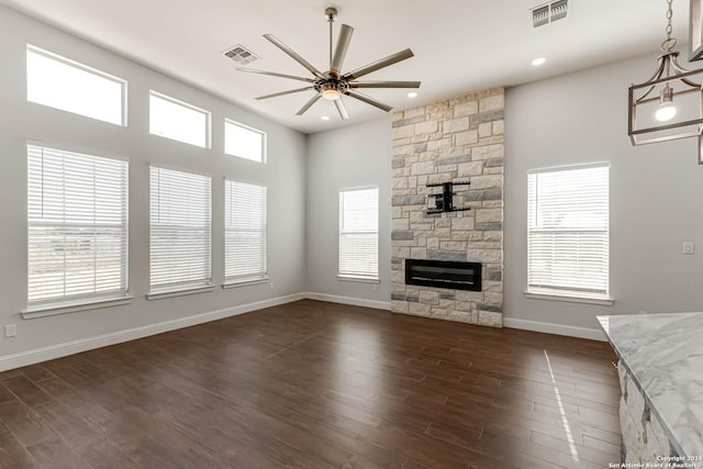 19146 Mcconnell Rd, Atascosa, TX 78002 - unfurnished living room with a ceiling fan, a stone fireplace, baseboards, recessed lighting, and dark wood finished floors