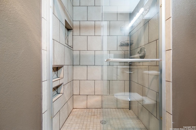 3243 Nacogdoches Rd Unit 501, San Antonio, TX 78217 - bathroom featuring a stall shower and a textured wall