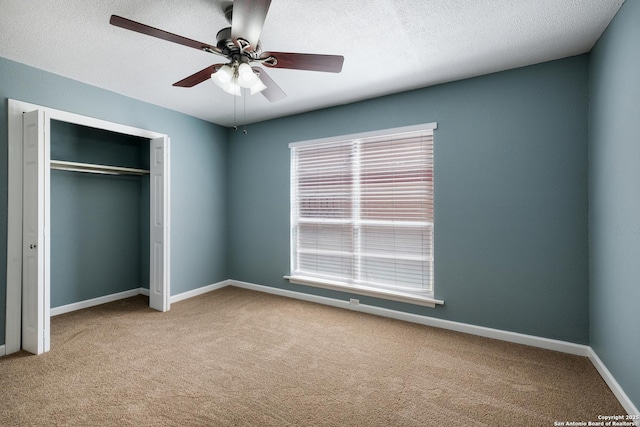3243 Nacogdoches Rd Unit 501, San Antonio, TX 78217 - unfurnished bedroom featuring carpet, a closet, baseboards, a textured ceiling, and a ceiling fan