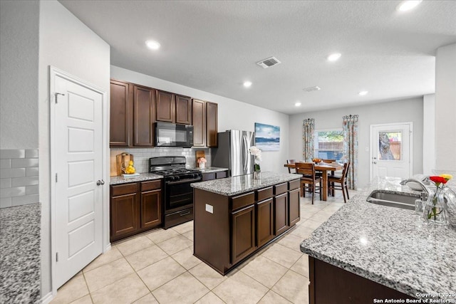 140 Whitetail Pass, San Antonio, TX 78253 - kitchen featuring black appliances, a kitchen island, backsplash, light stone counters, and dark brown cabinets