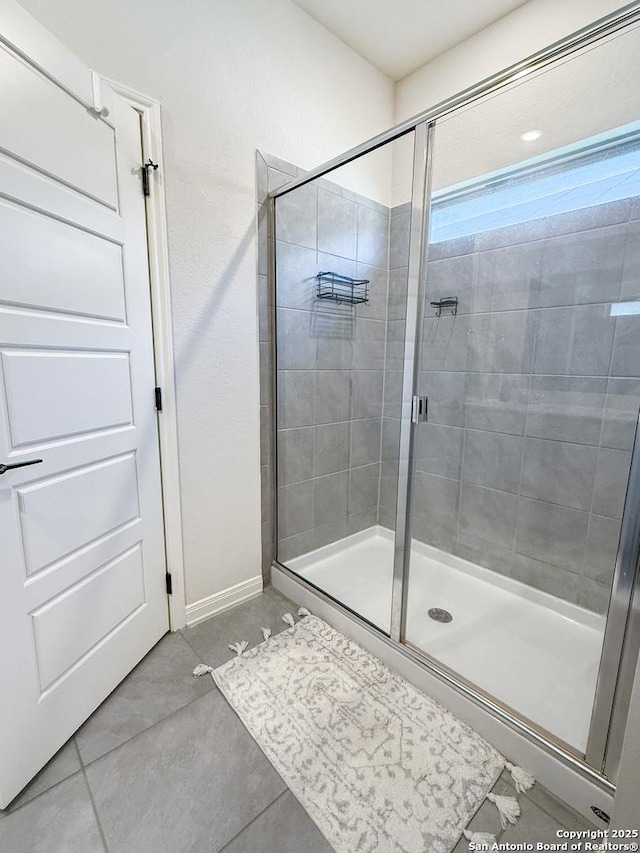 10227 Amaryllis, Boerne, TX 78006 - bathroom with a shower stall, baseboards, and tile patterned floors