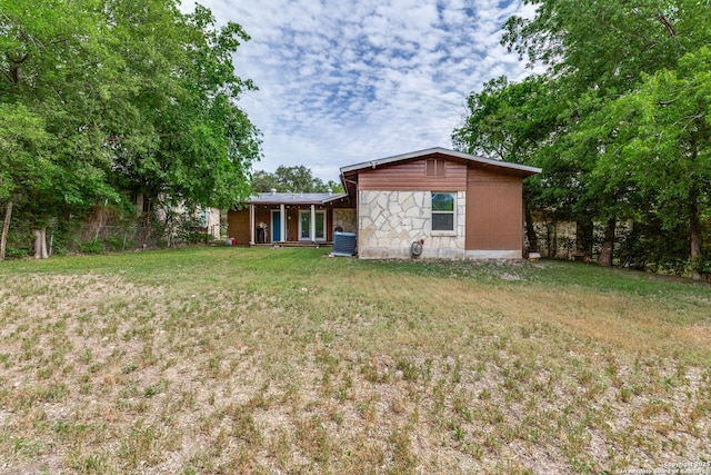 466 Shannon Lee, San Antonio, TX 78216 - back of property with a lawn, stone siding, and central air condition unit