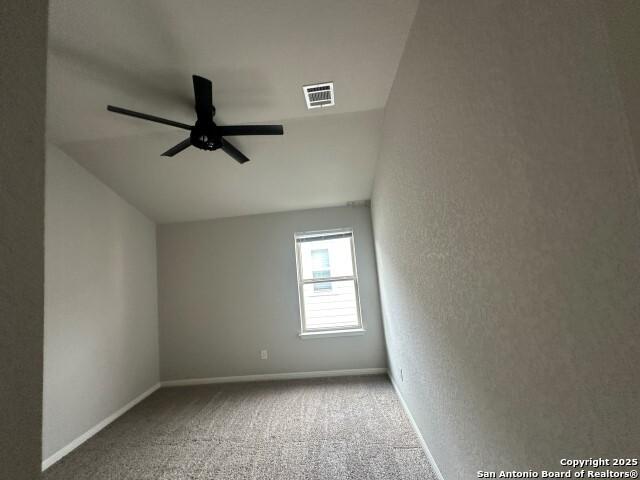 9536 Garrison Way, San Antonio, TX 78254 - carpeted spare room with a ceiling fan, baseboards, a textured wall, and vaulted ceiling