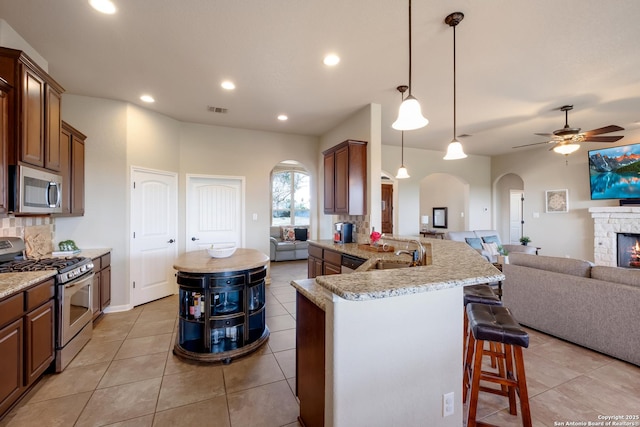 25838 Echo Mtn, San Antonio, TX 78260 - kitchen with stainless steel appliances, arched walkways, open floor plan, a breakfast bar, and a ceiling fan