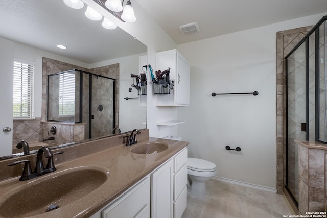 1303 Citlali Sun, San Antonio, TX 78245 - bathroom featuring a stall shower, toilet, and double vanity