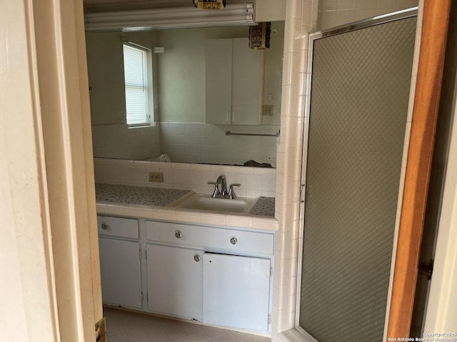 608 Leona St, Cotulla, TX 78014 - full bath with tile walls, tile patterned floors, vanity, and a tile shower