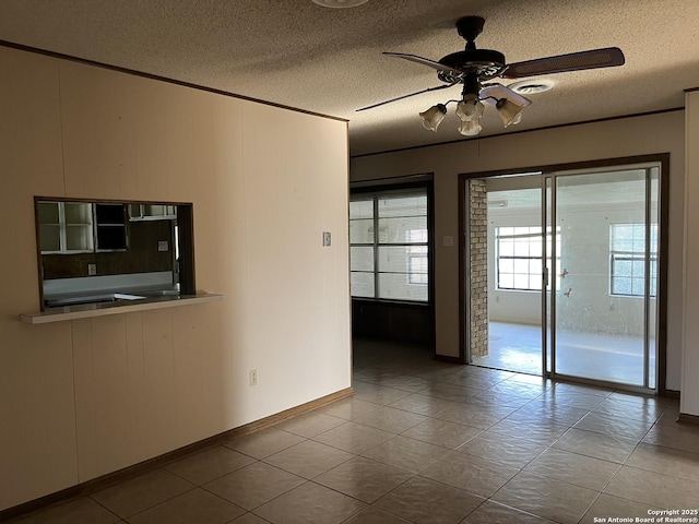 608 Leona St, Cotulla, TX 78014 - empty room with a textured ceiling, a ceiling fan, baseboards, and tile patterned floors