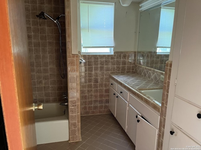 608 Leona St, Cotulla, TX 78014 - bathroom featuring tile walls, tile patterned floors, vanity, shower / washtub combination, and wainscoting