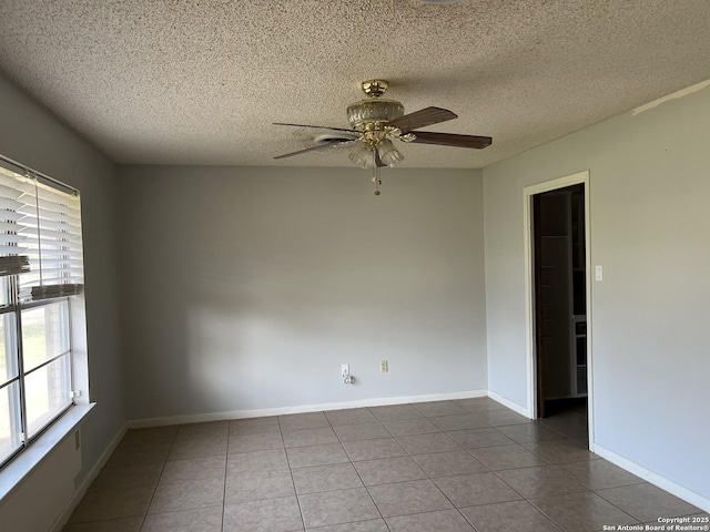608 Leona St, Cotulla, TX 78014 - tiled empty room featuring plenty of natural light, ceiling fan, a textured ceiling, and baseboards