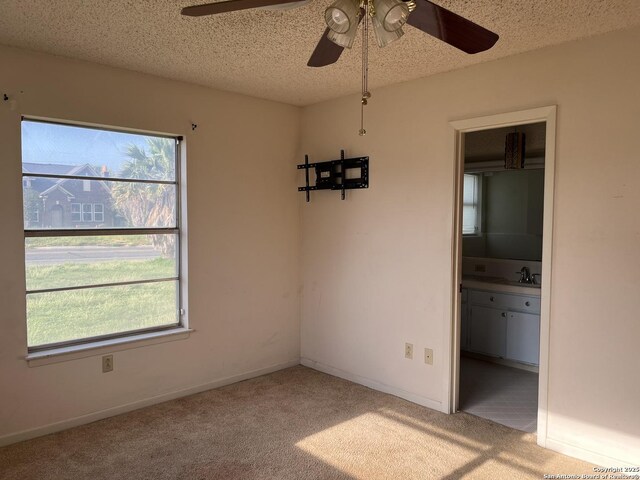 608 Leona St, Cotulla, TX 78014 - unfurnished room with healthy amount of natural light, a ceiling fan, carpet floors, and a textured ceiling