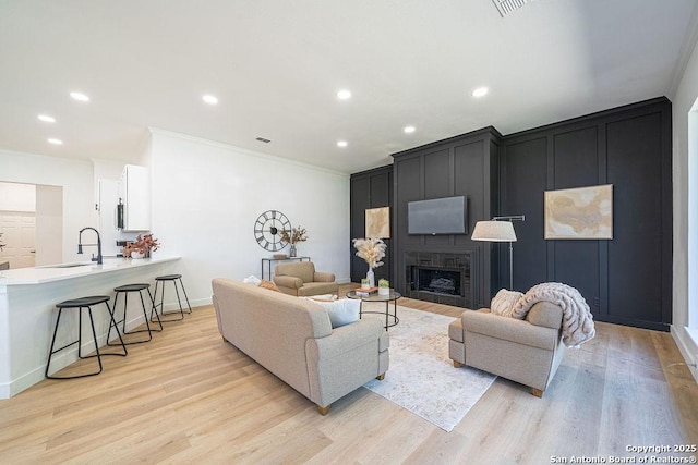 17338 Fountain Mist, San Antonio, TX 78248 - living area featuring ornamental molding, light wood-type flooring, recessed lighting, a fireplace, and baseboards