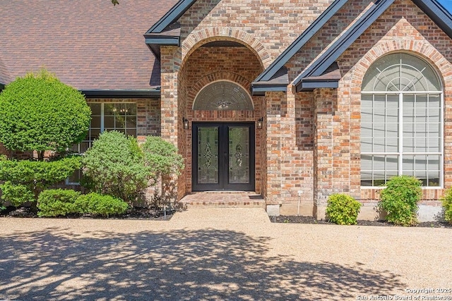 17338 Fountain Mist, San Antonio, TX 78248 - property entrance with french doors, brick siding, and roof with shingles