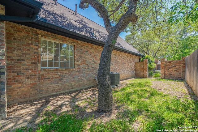 17338 Fountain Mist, San Antonio, TX 78248 - view of home's exterior featuring fence, brick siding, central AC, and a shingled roof