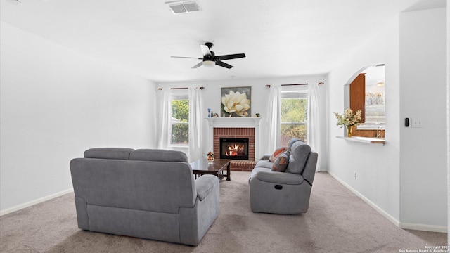 8818 Ash Mdw, Universal City, TX 78148 - living room with a ceiling fan, carpet floors, baseboards, a brick fireplace, and arched walkways