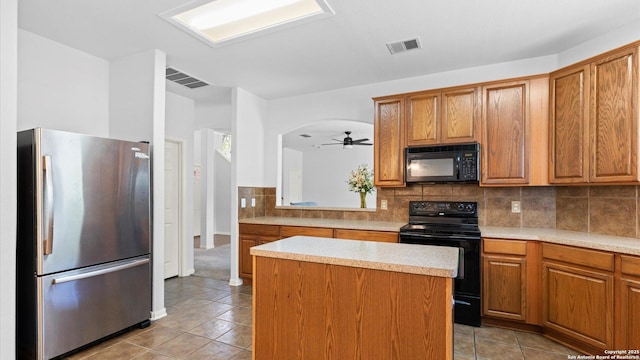 8818 Ash Mdw, Universal City, TX 78148 - kitchen featuring black appliances, light tile patterned floors, light countertops, and brown cabinetry