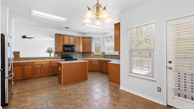 8818 Ash Mdw, Universal City, TX 78148 - kitchen with black appliances, light countertops, tile patterned flooring, backsplash, and a kitchen island