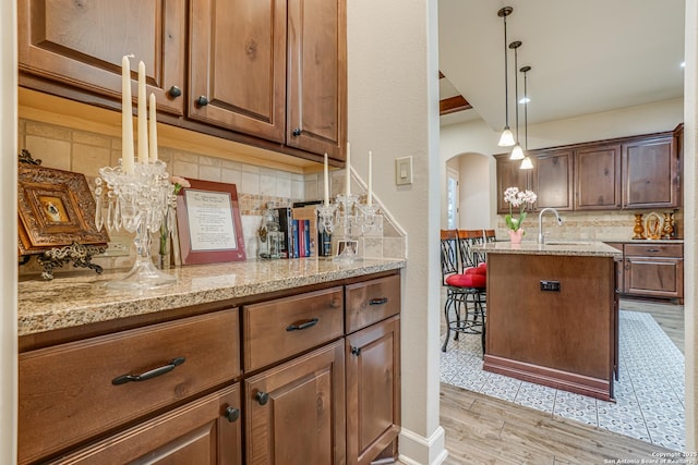1414 W Bitters # 3, San Antonio, TX 78248 - kitchen featuring arched walkways, backsplash, a sink, and light stone countertops