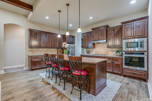 1414 W Bitters # 3, San Antonio, TX 78248 - kitchen with stainless steel appliances, under cabinet range hood, recessed lighting, a kitchen island with sink, and arched walkways