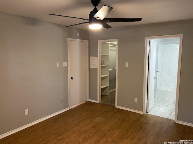 4803 Hamilton Wolfe Rd, San Antonio, TX 78229 - unfurnished bedroom featuring wood finished floors, a walk in closet, baseboards, a closet, and connected bathroom