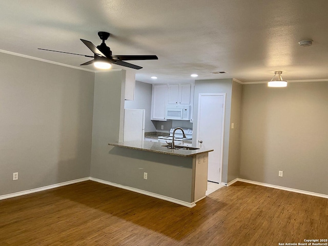4803 Hamilton Wolfe Rd, San Antonio, TX 78229 - kitchen featuring white appliances, a sink, a peninsula, wood finished floors, and ornamental molding
