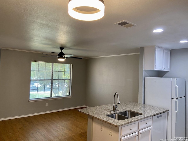 4803 Hamilton Wolfe Rd, San Antonio, TX 78229 - kitchen featuring a sink, freestanding refrigerator, white cabinetry, crown molding, and wood finished floors