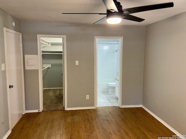 4803 Hamilton Wolfe Rd, San Antonio, TX 78229 - unfurnished bedroom with wood finished floors, a spacious closet, a closet, ensuite bath, and baseboards