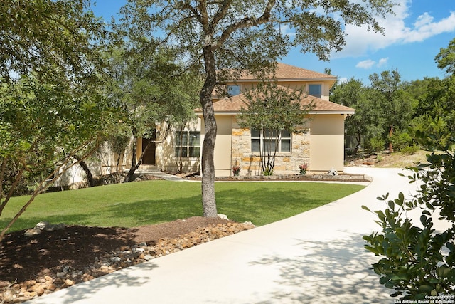 12302 Calvert, Helotes, TX 78023 - view of property hidden behind natural elements featuring stone siding, a front lawn, roof with shingles, and stucco siding