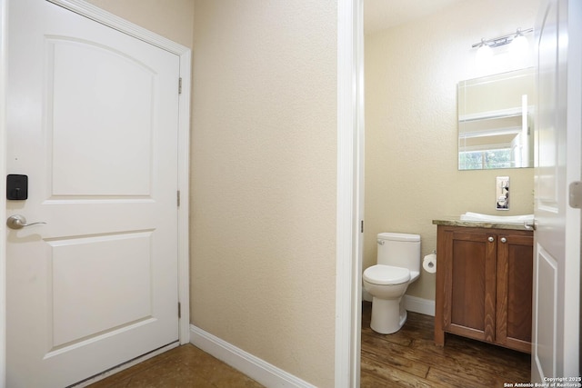 12302 Calvert, Helotes, TX 78023 - bathroom featuring vanity, toilet, wood finished floors, and baseboards