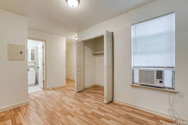 318 Elks, San Antonio, TX 78211 - unfurnished bedroom with light wood-style floors, baseboards, cooling unit, a closet, and ensuite bath
