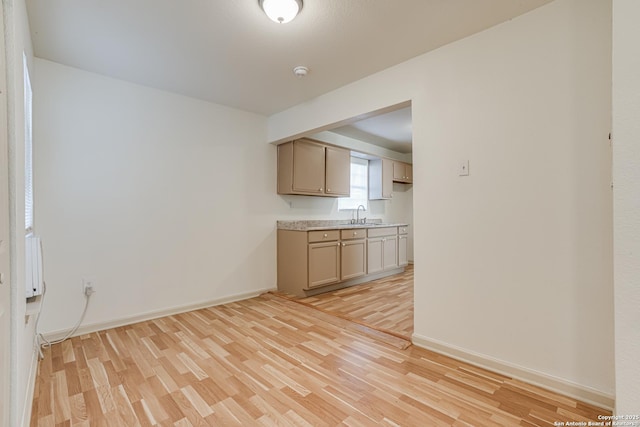 318 Elks, San Antonio, TX 78211 - kitchen featuring a sink, light wood-type flooring, light countertops, and baseboards